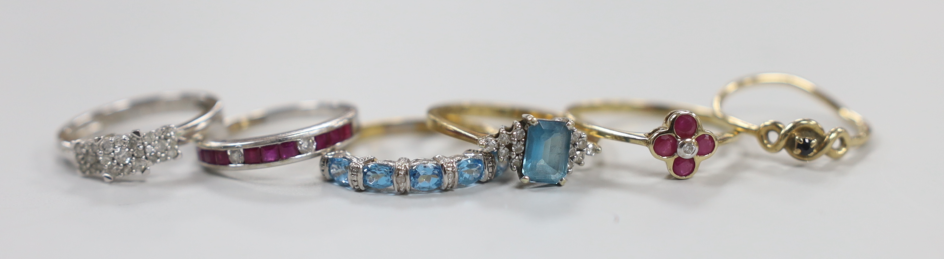 A modern 9ct white gold and diamond chip triple square cluster ring and a similar ruby and diamond set half hoop ring, together with four assorted modern 9ct gold and gem set rings, gross weight 11.2 grams.